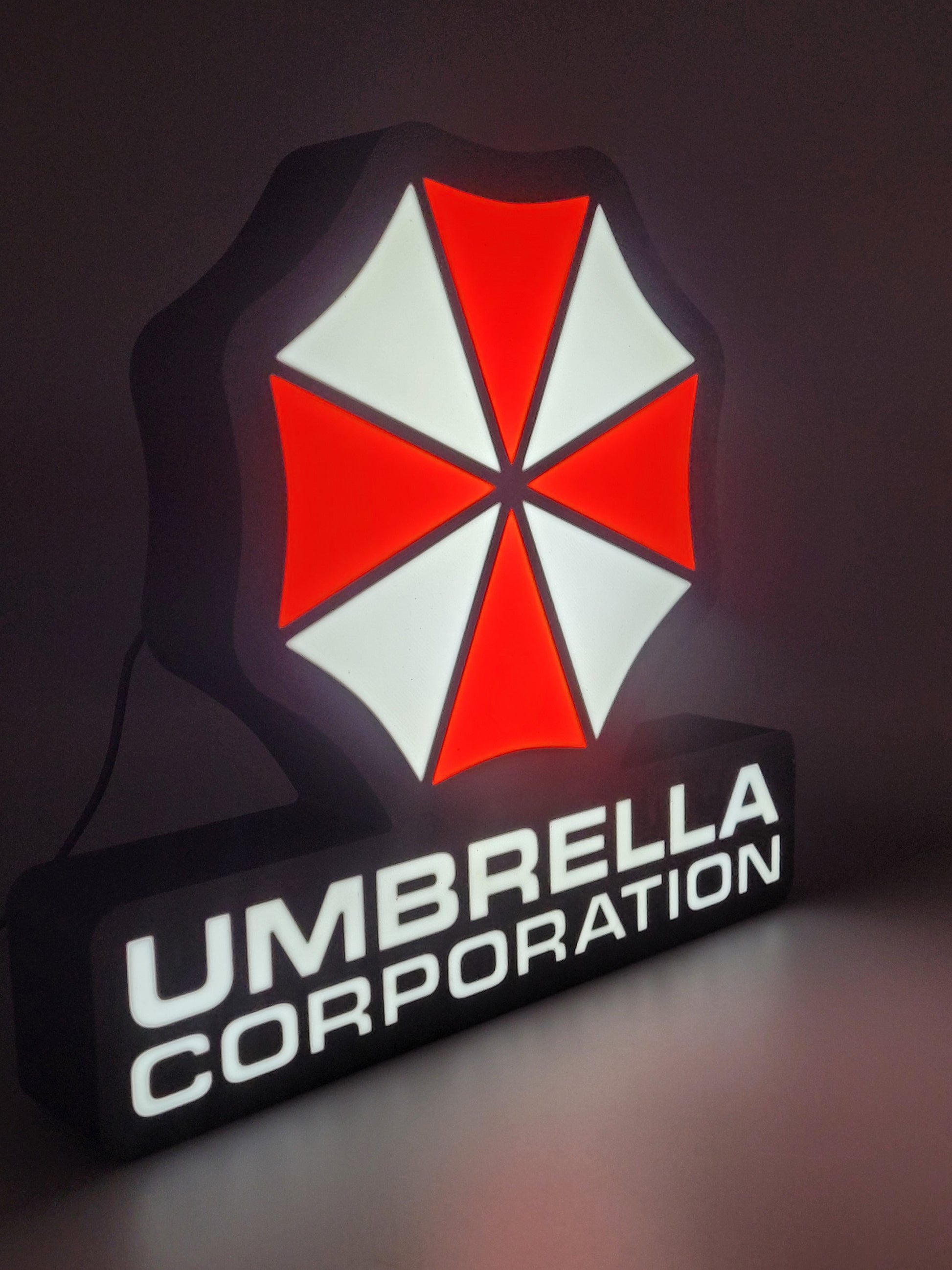 Umbrella Corporation logo with red and white umbrella design on a dark background