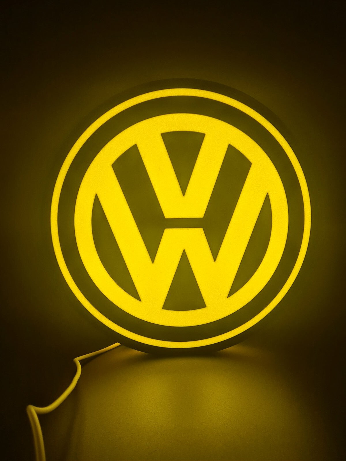 vw yellow LED light sign with illuminated logo viewed from straight on