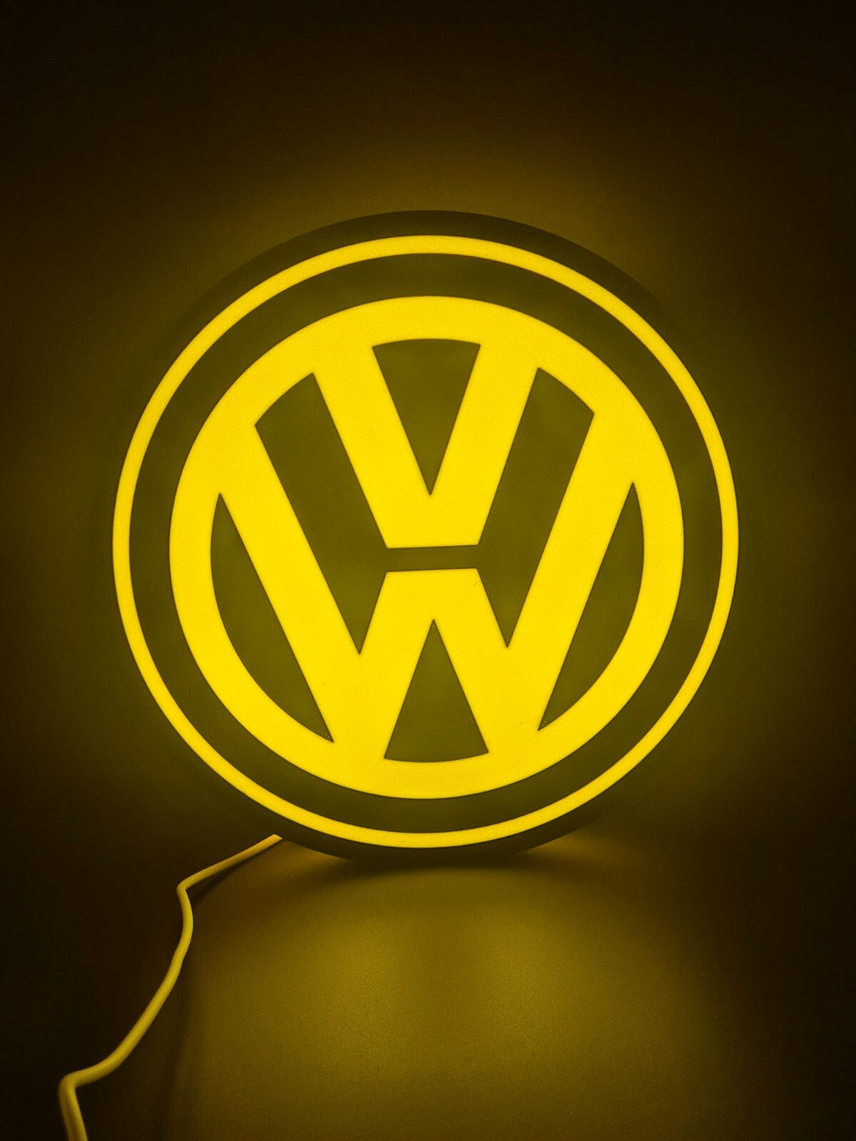 vw yellow LED light sign with illuminated logo viewed from straight on